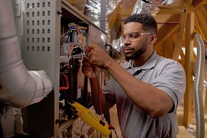 Technician inspecting furnace electrical components